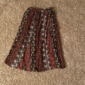 Longish skirt, white, orange, and red flowers all around the skirt.